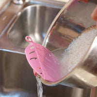 Durable leaf shape rice wash sieve in white color with handle.