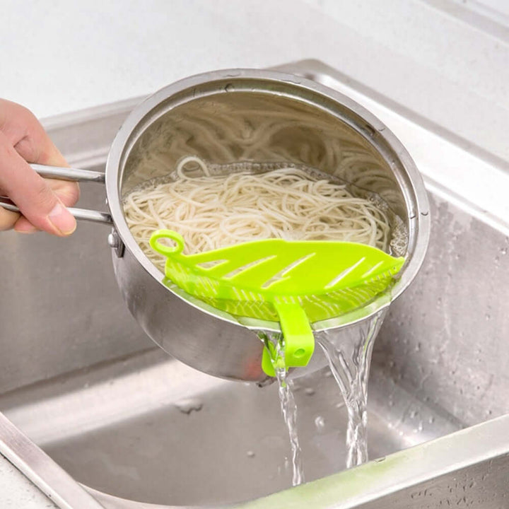 Durable leaf shape rice wash sieve in white color with handle.