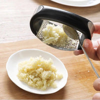Stainless steel garlic press with rubber handles.