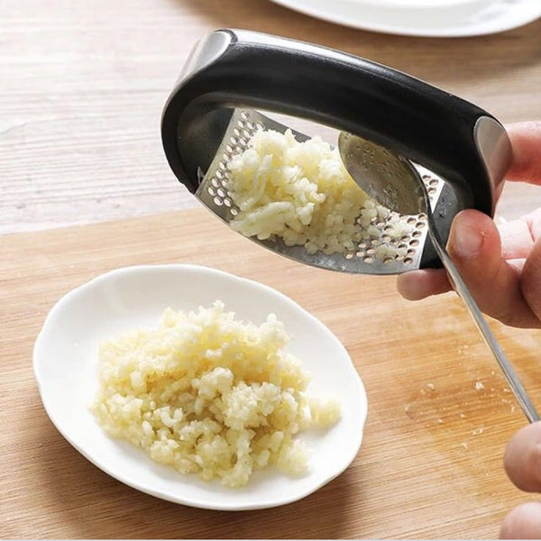 Stainless steel garlic press with rubber handles.