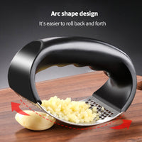 Stainless steel garlic press with black plastic handles.
