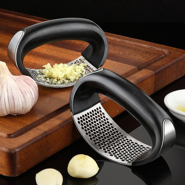 Stainless steel garlic press with black plastic handles.