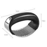 Stainless steel garlic press with black plastic handles.