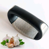 Stainless steel garlic press with rubber handles.