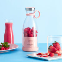 Smoothie Blender with fresh fruits and vegetables on a table.