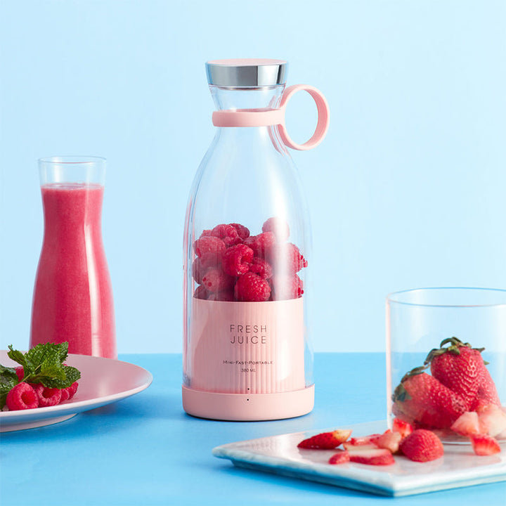 Smoothie Blender with fresh fruits and vegetables on a table.